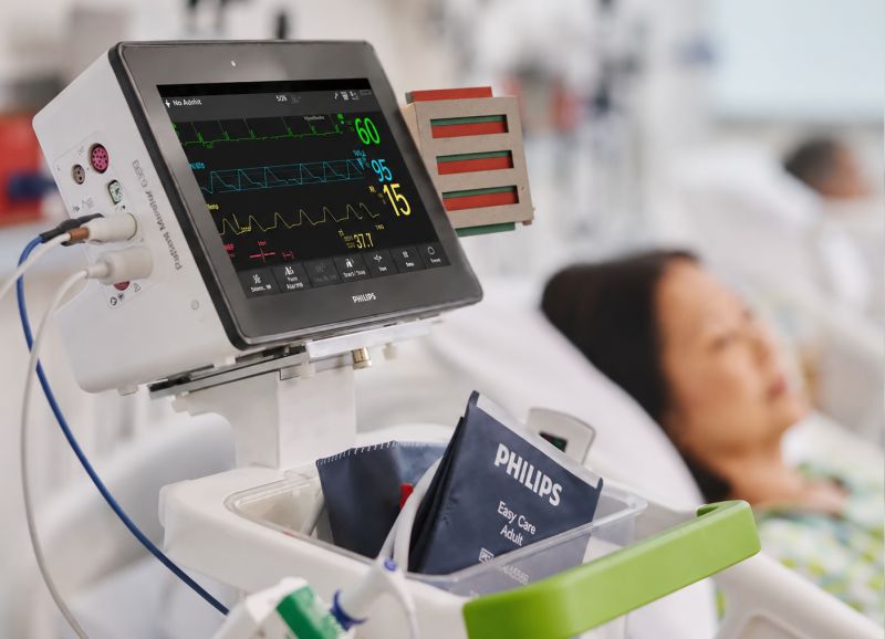 Philips IntelliVue monitor at a bedside with a patient in the background
